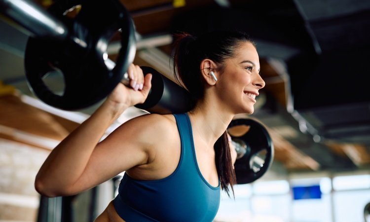 Lächelnde Frau beim Krafttraining in einem Fitnessstudio